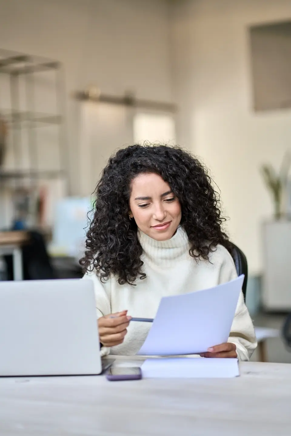Latina woman taking notes at computer