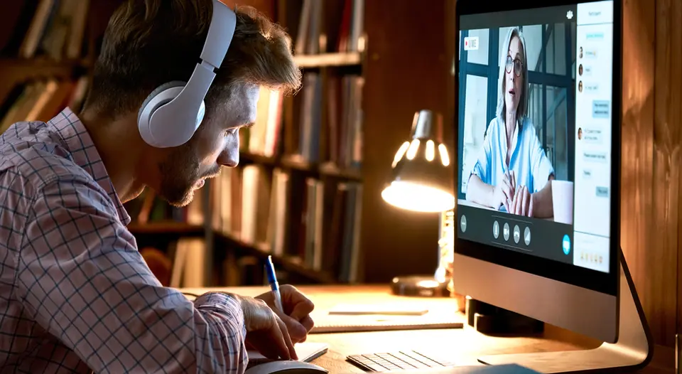 White man attending event on computer